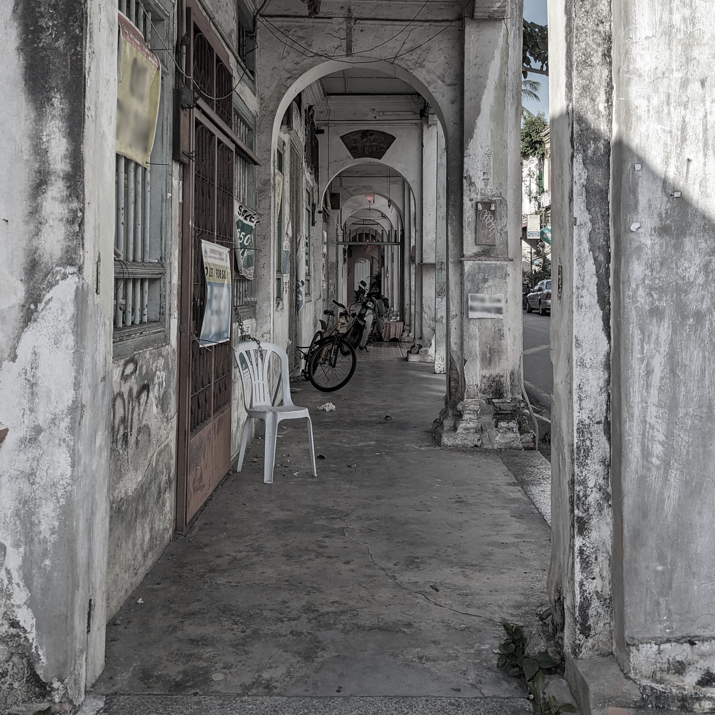 "Sticky Activities (Kusumo et.al., 2022), a photograph of a dilapidated five-footway made inaccessible by informal space uses such as seating and parking of bikes, business activities etc., and by changing floor levels along the path, George Town Penang". Image by the author (2023)